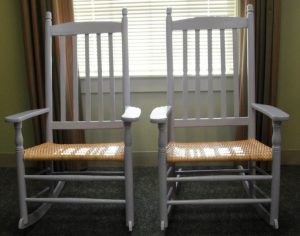 photograph of two white slat-back rocking chairs